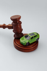 Wooden hammer of the judge and toy car on a white background. Insurance, court case. Vertical image.
