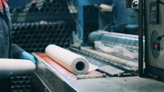 Paper factory worker making paper rolls using a special machine