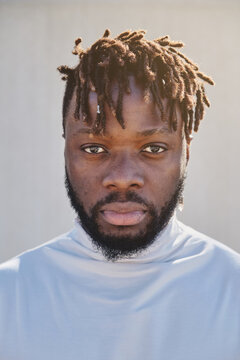 Calm African American male with dreadlocks looking at camera