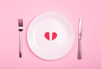 Heart on an empty plate on a pink background. Minimal art creative concept. Red heart as a symbol of love, romance and 