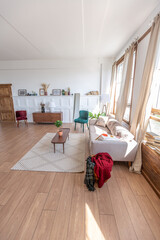 Vintage studio apartment interior in light colors in old style. huge room with large windows with a living room area and a bedroom area. direct sunlight inside.
