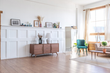 Vintage studio apartment interior in light colors in old style. huge room with large windows with a living room area and a bedroom area. direct sunlight inside.