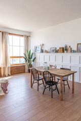 Vintage studio apartment interior in light colors in old style. huge room with large windows with a living room area and a bedroom area. direct sunlight inside.