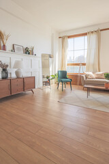 Vintage studio apartment interior in light colors in old style. huge room with large windows with a living room area and a bedroom area. direct sunlight inside.