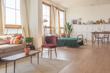 Vintage studio apartment interior in light colors in old style. huge room with large windows with a...