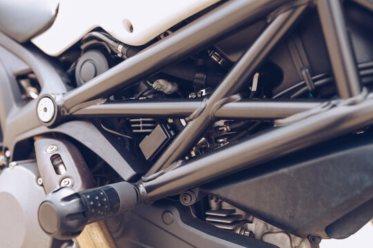 Detail of metal footrest of contemporary shiny motorbike parked in street at daytime