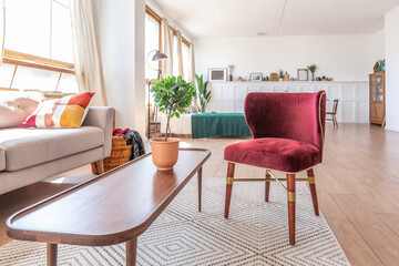 Vintage studio apartment interior in light colors in old style. huge room with large windows with a living room area and a bedroom area. direct sunlight inside.