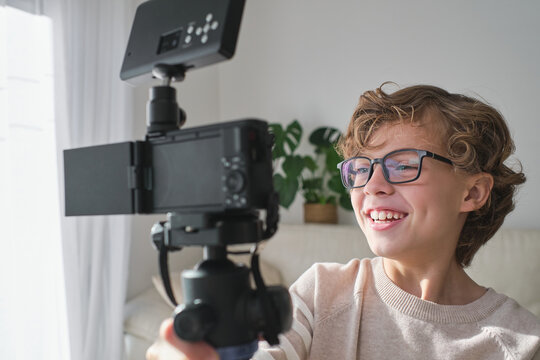 Cheerful boy making video in his house for his channel.
