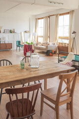 Vintage studio apartment interior in light colors in old style. huge room with large windows with a living room area and a bedroom area. direct sunlight inside.