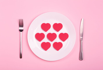 Heart on an empty plate on a pink background. Minimal art creative concept. Red heart as a symbol of love, romance and 