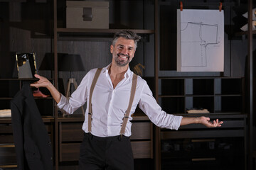 Stock photo of handsome man wearing suit and suspenders smiling and looking at camera.