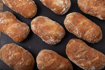 freshly baked  handmade ciabatta breads on black slate, 