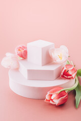 Solid Display Block for Shop Windows with tulips on pink background, empty podium for product presentation, geometric stand for cosmetics