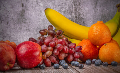 red apples and other fruits on dark wood background