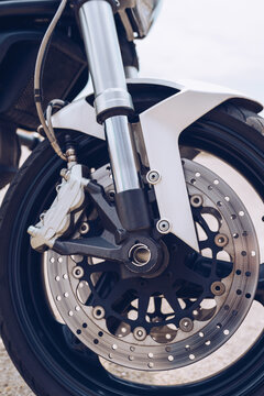 Closeup of front wheel with disk brake system and tire of modern motorbike