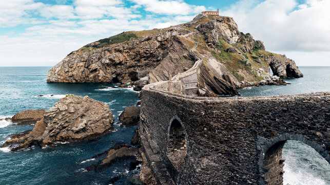 Spectacular panoramic scenery of rocky island of Gaztelugatxe and long stone bridge located in sea in Spain