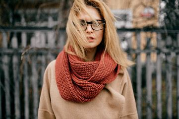 Portrait of young elegant blond girl with wind blown hair posing outdoors