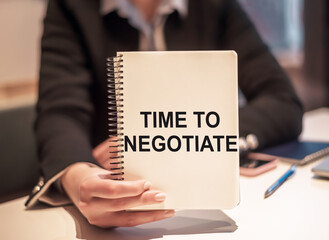Business woman holds a notebook with the text TIME TO NEGOTIATE.
