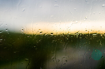 Closeup rainy drops on the bright window surface