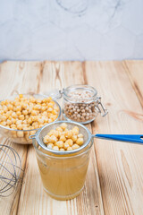 On a light wooden background, a decoction of Aquafaba chickpeas. Aquafaba is a source of vegetable protein. Copy space