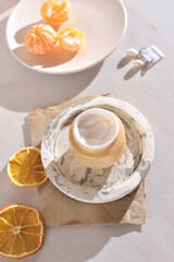 Beauty lifestyle background with Opened Jar of face cream and fresh tangerines.  winter skin care concept