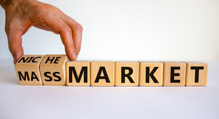 Mass or niche market symbol. Businessman flips wooden cubes and changes words 'mass market' to...