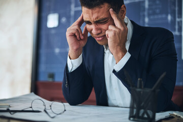 Young office worker suffering from a severe headache