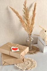 background with gift boxes wrapped in craft paper and decorated with a paper heart.