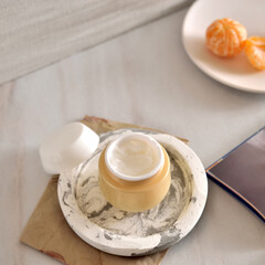 Beauty lifestyle background with Opened Jar of face cream and fresh tangerines.  winter skin care concept