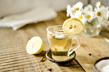 healthy served drink in the morning. A glass cup of green natural tea, lemon and chamomile