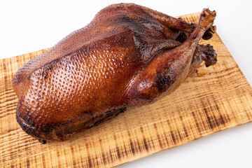 roasted, crispy golden goose on wooden board