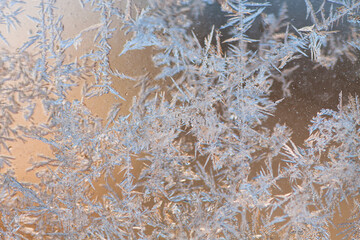 Eiskristalle in Glasscheibe mit bräunlichem Hintergrund
