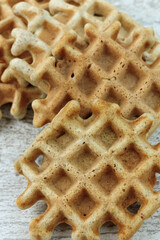 Vienna waffles lie in a row on a wooden table. 