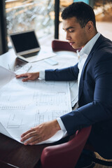 Concentrated draftsman staring at the building plan