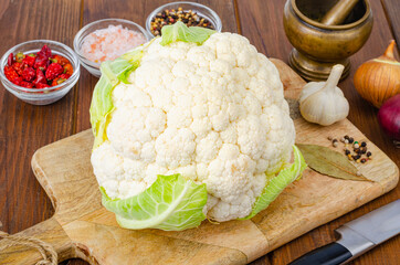 Head of cabbage fresh organic cauliflower on wooden background, spices. Studio Photo