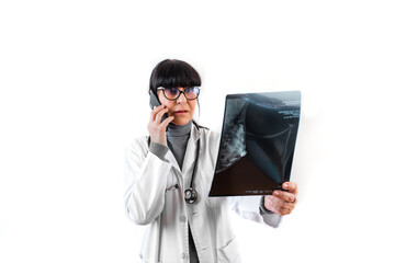 Female doctor talking on the phone while reviewing breast x-rays