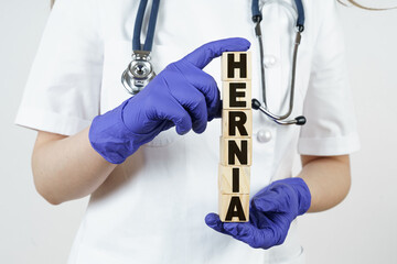 The doctor holds cubes in his hands on which it is written - HERNIA