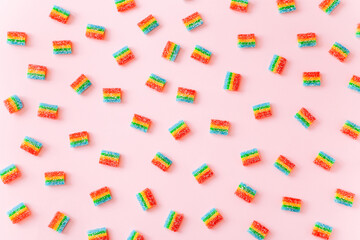 Rainbow juicy gummy candies background. Pattern from jelly sweets on pink background
