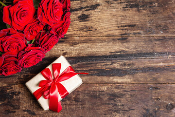 Fototapeta na wymiar Valentine greeting card background with a gift box and fresh burgundy roses