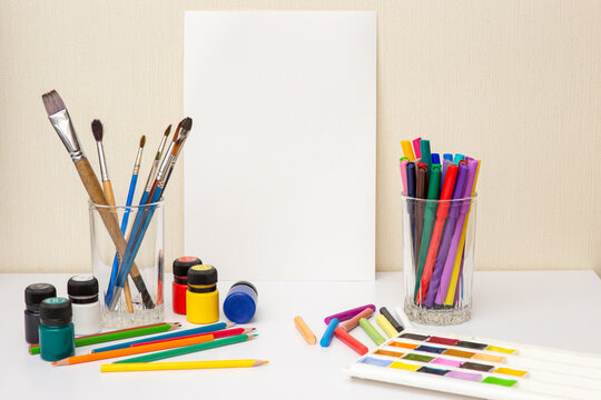 White table with colorful drawing supplies. Mock up