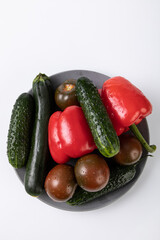 Fresh vegetables with water droplets from market, on grey plate with white background