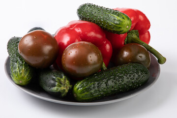 Fresh vegetables with water droplets from market, on grey plate with white background