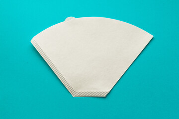 Bleached paper coffee filter for immersion brewing isolated on a colored blue background. Alternative brewing v60 pour over method. Minimalistic abstract background