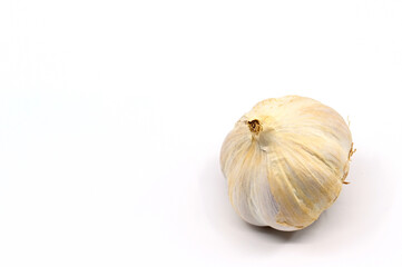 Close up of a single bulb of fresh garlic or "Allium sativum" on a plain white background. No people. Copy space.