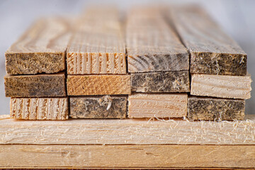 Stacked raw planks. Material for use in a carpentry workshop.