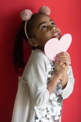 Portrait of a girl with a paper heart on color background	