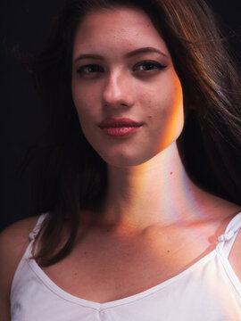 Portrait Of One Young Woman, Posing In Photo Studio With White Background And Rainbow Light Effect Created From Prism.