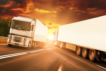 Abstract background with trucks on a road against a sky with a sunset