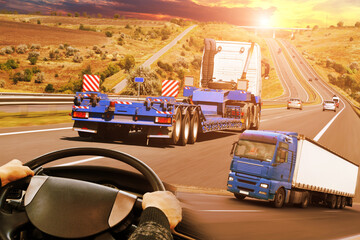Abstract background with trucks on a road, truck steering wheel against a sky with a sunset