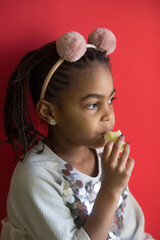 Little afro girl eating an apple